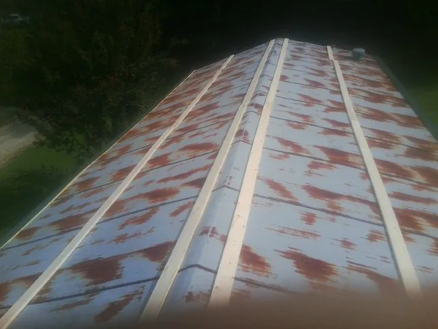 Rusted metal roof panels with new wood purlins before replacement — Storm Damage Roof Repair in Guthrie Center by Roofing Brothers