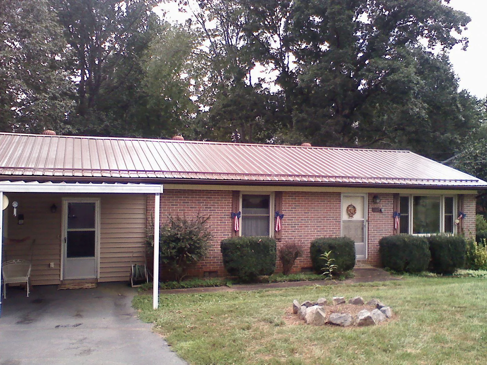 Bronze metal roof and carport on a brick ranch home — Roof Repair work by our crew in Guthrie Center